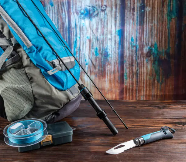 A close-up of a tackle box filled with assorted fishing tackle including hooks, sinkers, and lures, showcasing the variety of gear needed for a successful fishing trip.