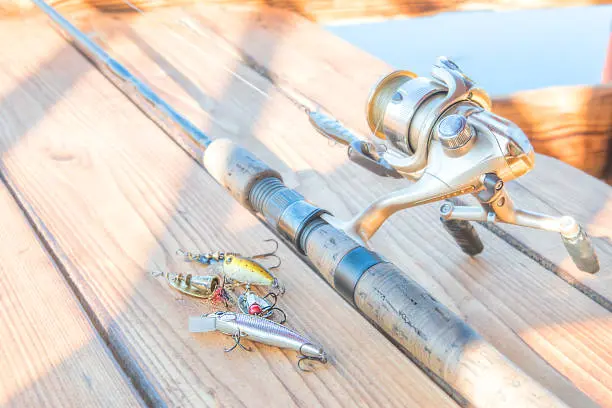 Close-up of an angler's hands holding a freshly caught fish against the backdrop of a stunning natural landscape, showcasing the thrill of the catch and the beauty of the environment in fishing photography.